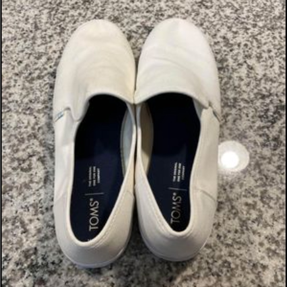 Tom’s white slip-ons